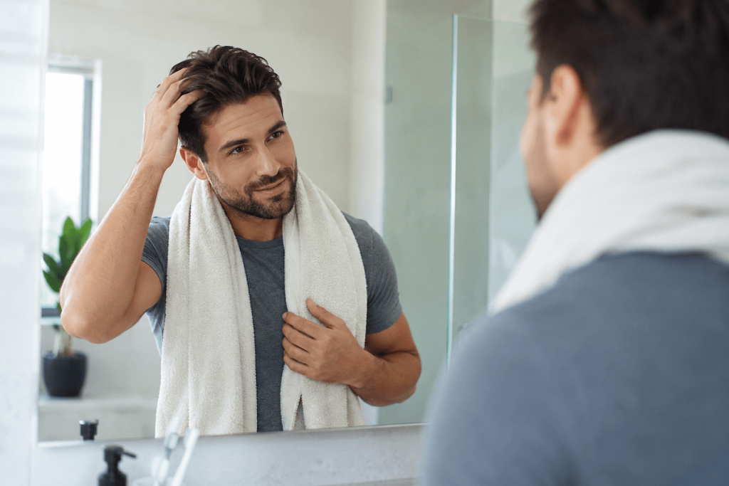 Man styling his hair as part of a normal daily grooming routine